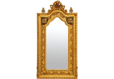 A sensational and richly carved mid 18th century Italian Baroque style pier mirror, gilded with French gold foils 18th carat and applied with patina, The double heavy giltwood frame has an inner and outer mottled border. The outer border is carved and ornamented with gadrooned, foliate egged motifs and beaded row shaped interior borders. The richly carved giltwood inner border displaying a detailed trailing large acanthus leaves and striking foliate movements and patterns with two baroque style royal symbols to each side with a darker background. The frame is terminating with S shape scrolled acanthus leaf to each side, The elaborate naturalistic central reserve top with pierced crown issuing C scroll-works and blossoming flowers and pierced leafy works. At each side is an shaped urn of prosperity finial adorned with giltwood bands